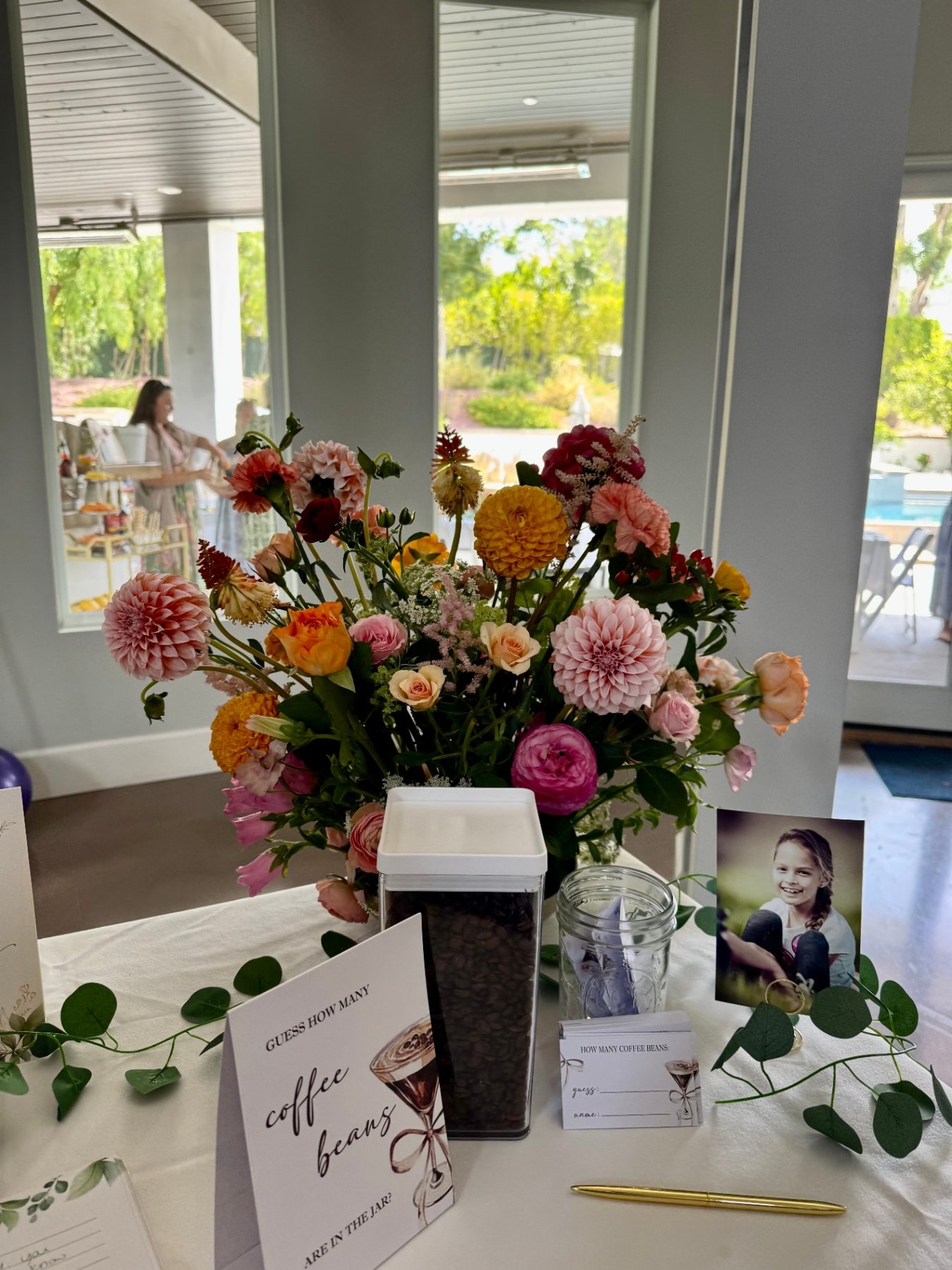 Lush bouquet of dahlias, ranunculus, and roses on a welcome table