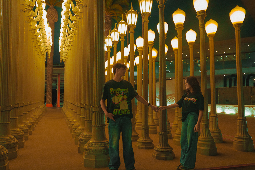 Couple holding hands among glowing vintage lamp posts at night