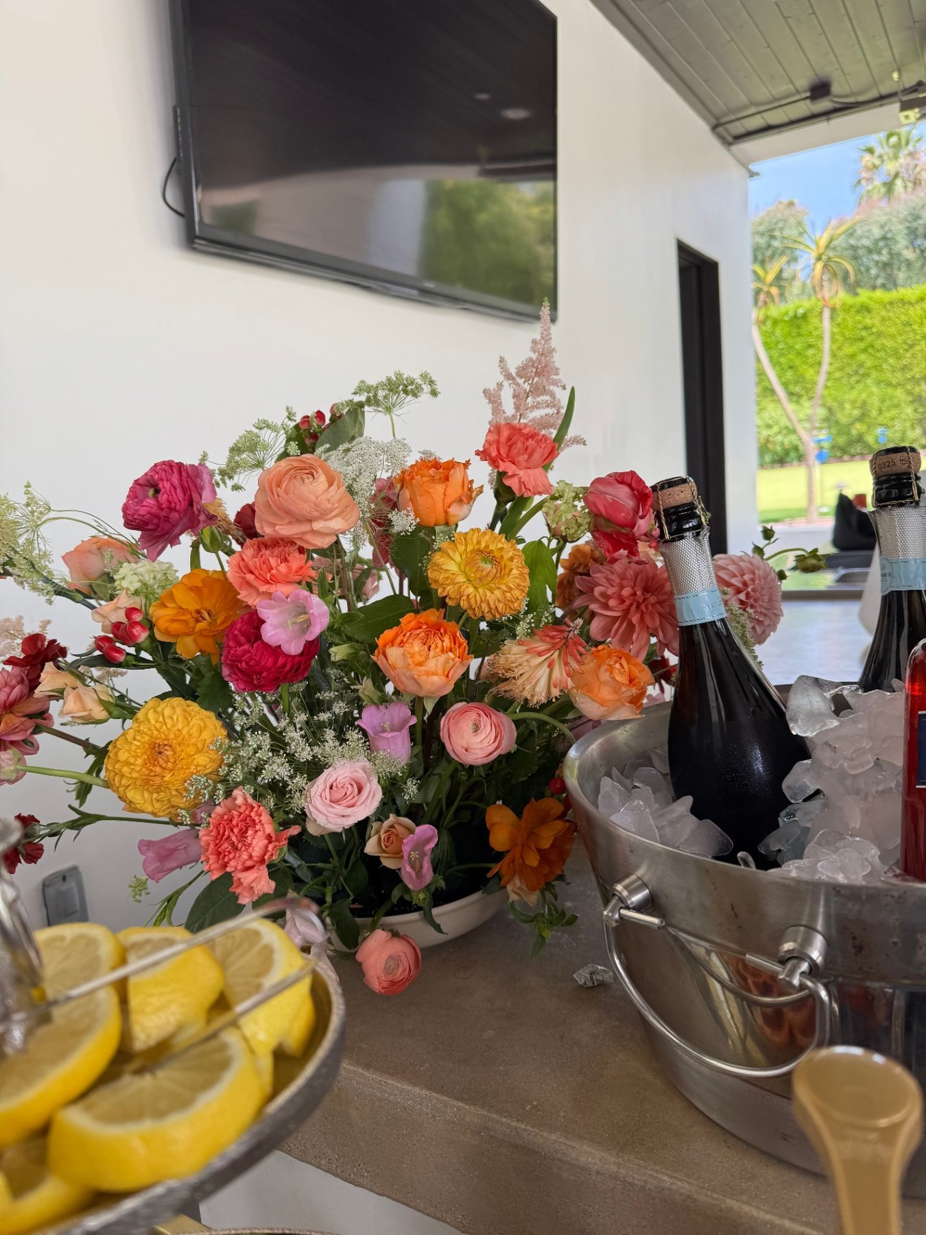 Colorful event florals beside a champagne bucket with lemon slices