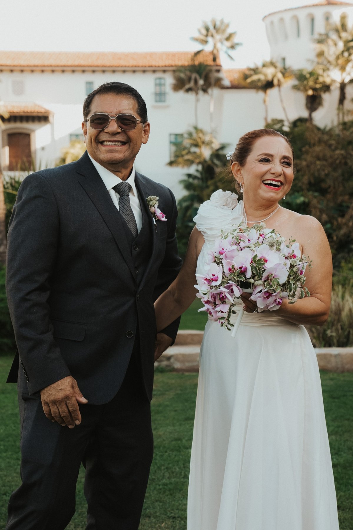 Newlyweds laughing together in a garden courtyard