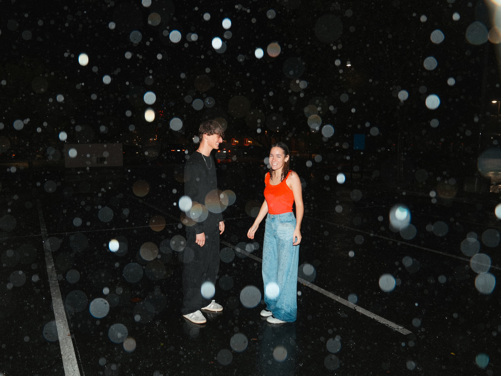 Couple laughing together in the rain under warm light