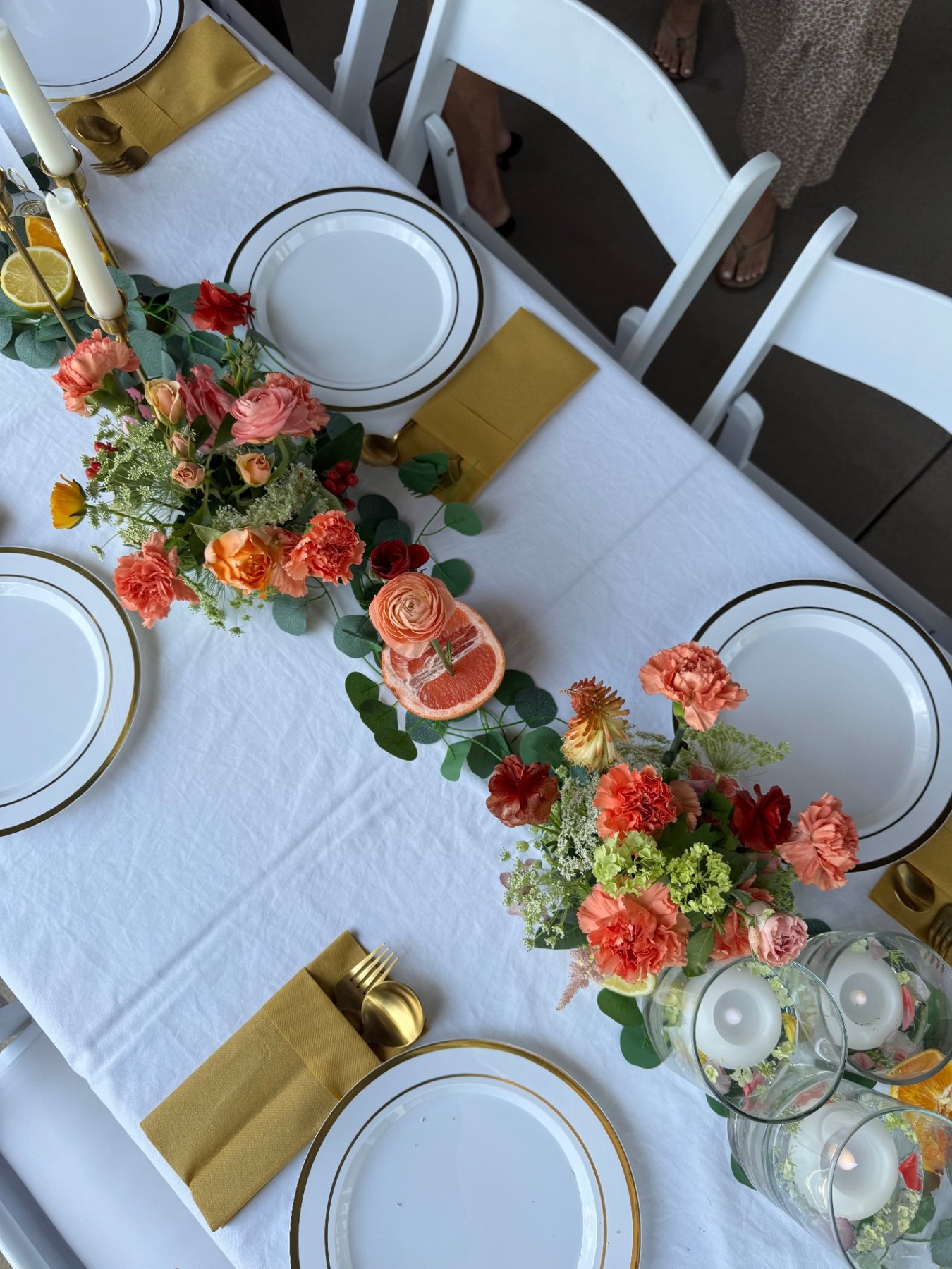 Citrus-themed tablescape with floral garland, grapefruit, and gold accents